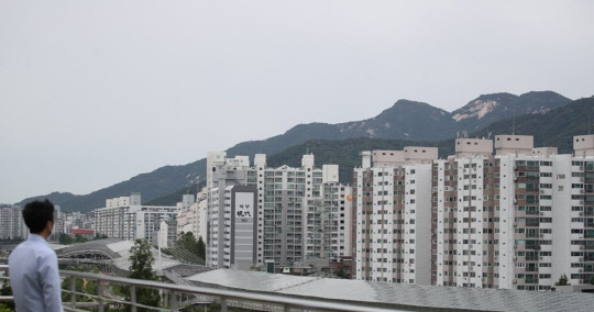 한 시민이 서울 노원구 상계동 아파트 단지 일대를 바라보고 있다. <연합뉴스>